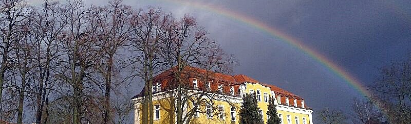Bilder der Haus auf dem Campus mit Regenbogen zeigt