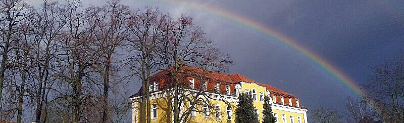 Bilder der Haus auf dem Campus mit Regenbogen zeigt
