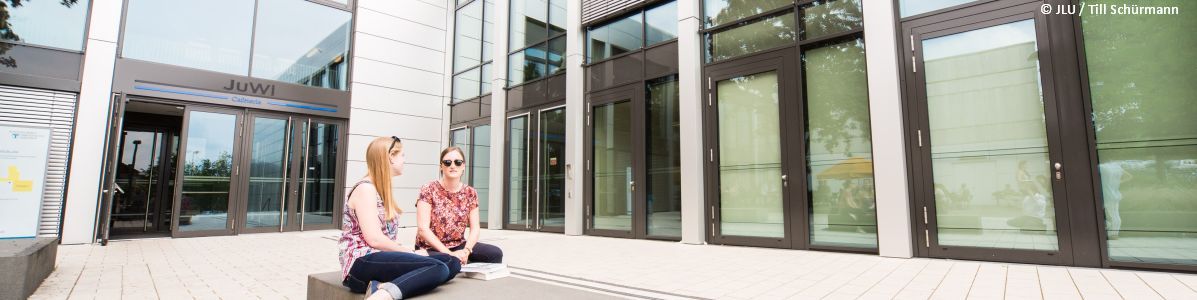 Studierende vor der Cafeteria JuWi auf dem Campus Licher Straße