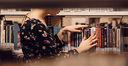 Studentin sucht Bücher in einer Bibliothek