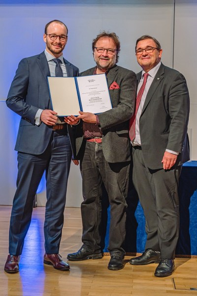Prof. Martin Kramer (r.) und Prof. Volker Wissemann (m.) gratulieren dem Preisträger Dr. Philip Klement (l.). Foto: JLU / Roland Duss
