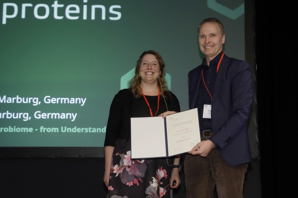 Katharina Höfer receiving the Otto Meyerhof Prize 2024 from GBM President Volker Haucke at the Mosbach Kolloquium. (Foto: Uwe Dettmar; Copyright: GBM e.V.)