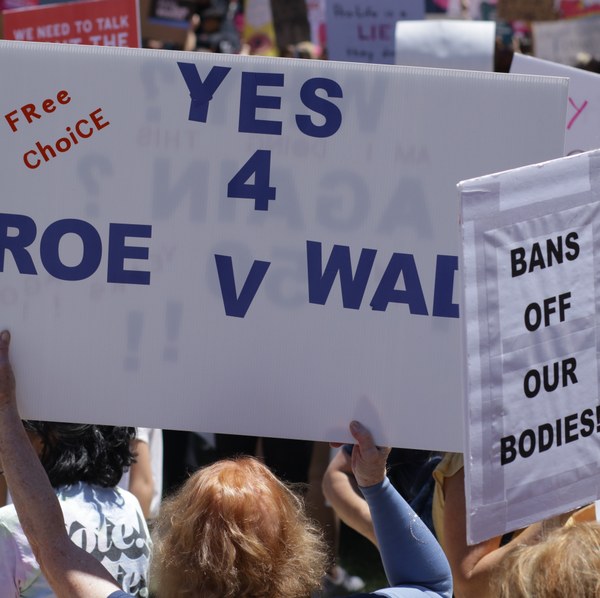 Eine Gruppe von Menschen, die Schilder zum Thema "Pro Choice" in die Luft halten