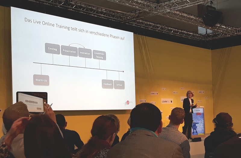 Sie sehen wie Frau Inga Geisler einen Vortrag auf der Learntec hält