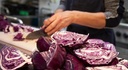 Person cutting red cabbage