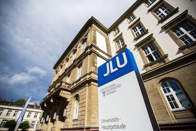 Das Hauptgebäude der Justus-Liebig-Universität mit kennzeichnender Stele und Fahnen