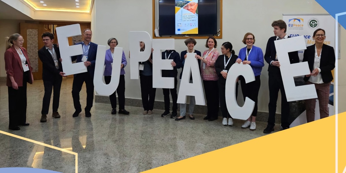 Decorative graphic: the EUPeace team holding large white letters spelling the word EUPeace.