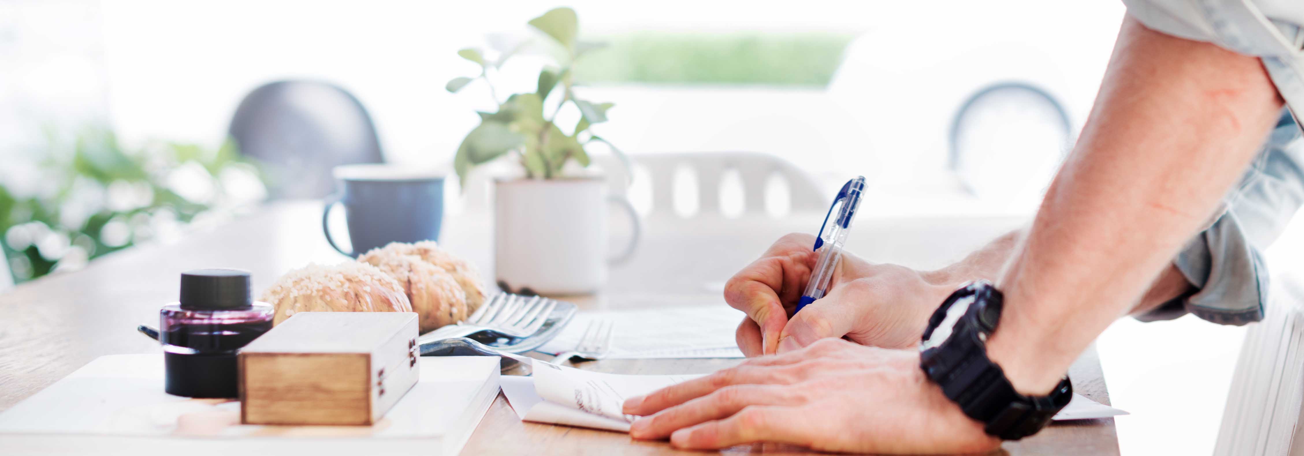 Slider:Fotografie von Händen an einem Schreibtisch, die Notizen mit einem Kugelschreiber macht (Bildbeschreibung und Bildnachweis siehe Quellenverzeichnis) / Slider:  Photography of hands on a desk that make notes using a pen