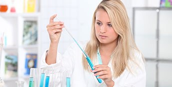 Sectionimage: Auszubildende im Labor mit einer Pipette und einem Reagenzglas