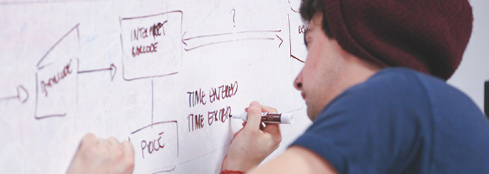 Bild: Person die Notizen auf einem Whiteboard macht // Photo: Person taking notes on a whiteboard