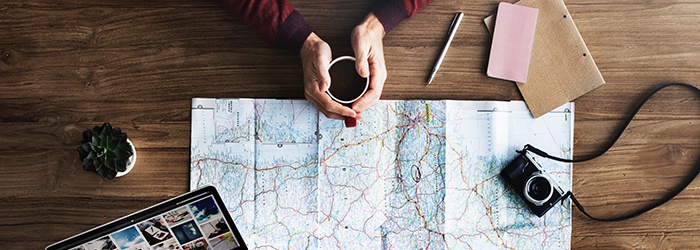 Bild: Landkarte mit Händen einer Person mit Kaffee // Photo: Map with the hands of a person holding a coffee