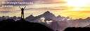 Bild: Frau steht auf Bergspitze und reckt Arme in den Himmel / Photo: woman standing on a mountain top is raising her arms in the air