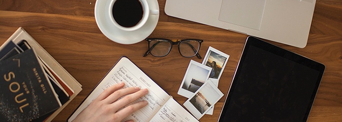 Bild: Banner der einen Schreibtisch mit Kaffee, Terminkalender und Laptop zeigt // Photo: Banner showing a wooden desk with a mug of coffee, a diary and a laptop on it