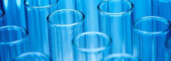 Bild: Blick auf Reagenzgläser in Reihen vor blauem Hintergrund // Photo: View of test tubes in rows against a blue background