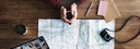 Bild: Landkarte mit Händen einer Person mit Kaffee // Photo: Map with the hands of a person holding a coffee