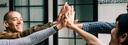 Bild: Lachende Menschen, deren sich abklatschende Hände im Fokus stehen // Photo: People laughing with the focus on their hands as they give each other high fives