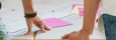 Bild: Ausschnitt zweier Personen, die vor einem Plan stehen (schmal) // Photo: Detail of two people standing in front of a plan