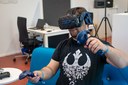 Mann benutzt eine VR-Brille mit Controllern.
