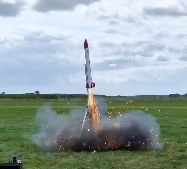 Eine kleine Rakete startet von einer Wiese