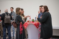 Gruppen von Studierenden und Alumni im Gespräch an Stehtischen_1