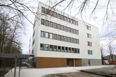Ein mehrstöckiges weißes Gebäude mit Flachdach.