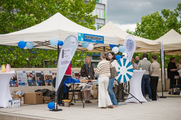 OCD_Recht.jpg Pavillons mit Informationen, junge Menschen im Gespräch und ein blau-weißes Glücksrad im Vordergrund..