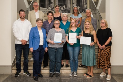 JLU-Vizepräsidentin für Studium und Lehre Prof. Dr. Katharina Lorenz (2.v.l.) und JLU-Kanzlerin Susanne Kraus (r.) gratulierten dem Team des Akademischen Prüfungsamts der Geisteswissenschaften zum Arbeitssicherheitspreis. Foto: JLU / Katrina Friese