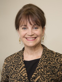 Frau Baillargeon lacht in einer Nahaufnahme in die Kamera.