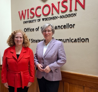 Dr. Jennifer L. Mnookin steht links mit roter Jacke. Rechts daneben steht Prof. Dr. Katharina Lorenz mit lila Jacke vor einer Tafel mit dem Schriftzug Wisconsin.