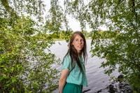 Frau Meijer im T-Shirt vor einem See mit Bäumen umrahmt.