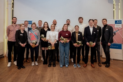 Die Justus-Liebig-Universität Gießen würdigt herausragende Sportlerinnen und Sportler im Faculty Club (vorn links Lena Schalski, Leiterin des Allgemeinen Hochschulsports (ahs), rechts Prof. Dr. Karsten Krüger, Vizepräsident für Wissenschaftliche Infrastruktur). Foto: JLU / Katrina Friese