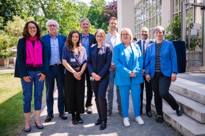 Gruppenbild im Botanischen Garten (v.l.): Angela Dorn, Hessische Ministerin für Wissenschaft und Kunst, Prof. Dr. Claus Leggewie, Inhaber der Ludwig Börne-Professur und wissenschaftlicher Direktor des Panel on Planetary Thinking, Liza Bauer, stellvertretende Geschäftsführerin des Panels, Prof. Dr. Peter Winker, zentraler Nachhaltigkeitsbeauftragte der JLU, Dr. Alexandra Jungert, Leiterin des Büros für Nachhaltigkeit, Dr. Frederic Hanusch, wissenschaftlicher Geschäftsführer des Panel on Planetary Thinking, Susanne Kraus, Kanzlerin der JLU, Prof. Dr. Joybrato Mukherjee, JLU-Präsident, und Prof. Dr. Katharina Lorenz, JLU-Vizepräsidentin für Studium und Lehre. Foto: JLU / Katrina Friese