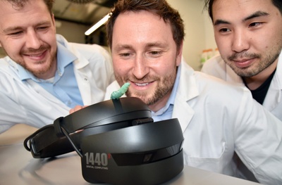 Die Gießener Biologen und Studienautoren Dr. Anton Windfelder (mittig) Dr. Jan Scherberich (links) sowie Informatiker und VR-Experte Viet Duc Vu (rechts) mit einer Tabakschwärmerlarve auf dem VR-Headset. Foto: Fraunhofer IME / Kim Weigand