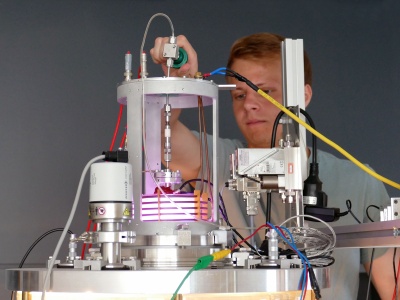 Gemeinsam forschen zahlreiche Wissenschaftlerinnen und Wissenschaftler von JLU und THM an Themen rund um elektrische Raumfahrtantriebe für Satelliten. Das Bild zeigt den Doktoranden Philip Peters bei der Zündung eines an der JLU entwickelten Radiofrequenz-Ionentriebwerks. Foto: Melanie Diehl 