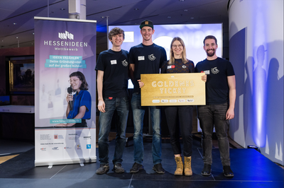 Im Finale des „Hessen Ideen Wettbewerbs“ hat das Gießener Studierenden-Team „HybridLaunch“ den Publikumspreis gewonnen. Diesen nahmen (v.li.) Alex Daniel Stamm, Nico Krug, Stephanie Käs und Paul Silas Moos entgegen. Foto: Mario Andreya