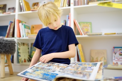 A child flipping through a large picture book