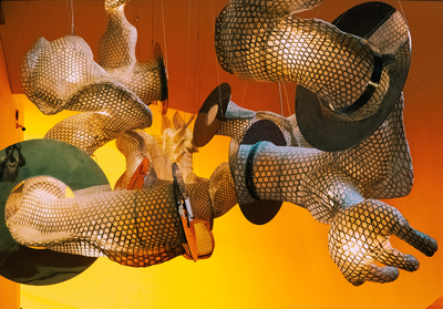 Source: https://unsplash.com/photos/oJhaFeoRFDw ; copyright: Adrian N on unsplash Image of an art installation of fabric-like material in arm- and hand-like shape hanging from the ceiling