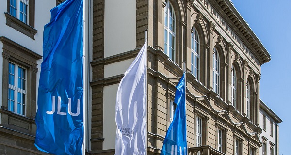 University main building with hoisted JLU flags