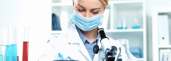 Photo: Woman in the laboratory at the microscope with mouthguard