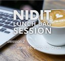 Laptop and a coffee cup, a white lettering saying NIDIT Lunch Bag Session 2