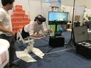 A lying man wearing VR-glasses, fair stands in the back