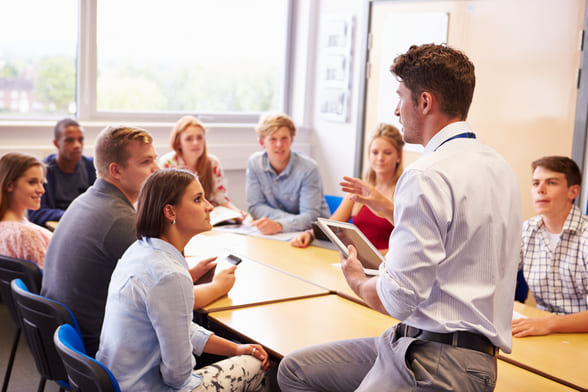 Pädagogischer Mitarbeiter im Austausch mit Studierendengruppe (Foto: Colourbox.de)