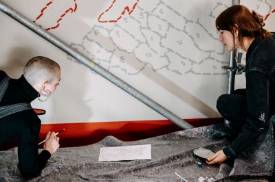 Zwei Studentinnen bei ihrer Arbeit zur Bemalung der Wand