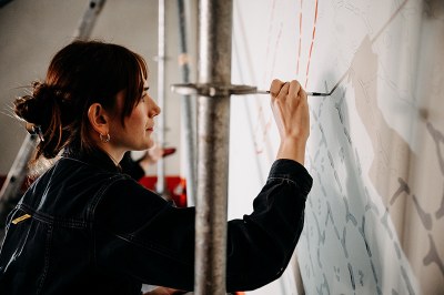 Profilaufnahme: Eine der Studentinnen bemalt die Wand 
