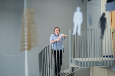 Prof. Dr. Wissemann im Zentrum des Bildes. Links und rechts erkennt man verschwommen die einzelenen Elemente des Mobiles